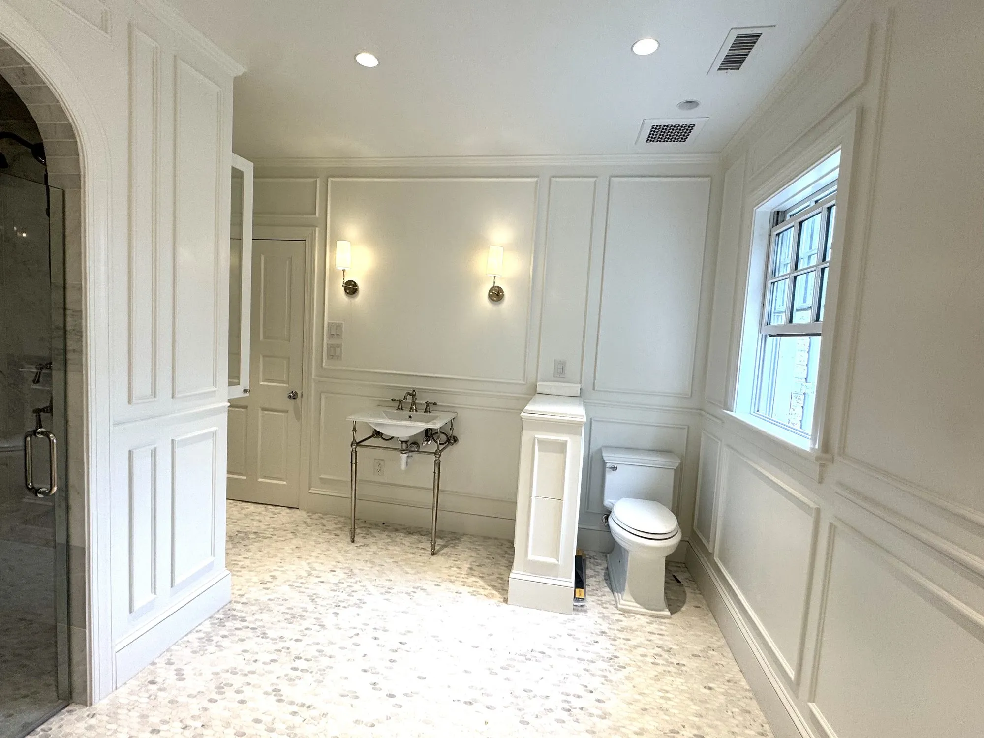 Custom bathroom remodel with wainscoting and marble tile by Building America Construction